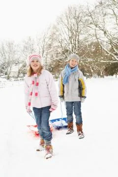 Children Pulling Sledge Through Snowy Landscape Stock Photos