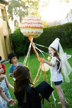 Children pulling streamers attached to pull string pinata Foto stock