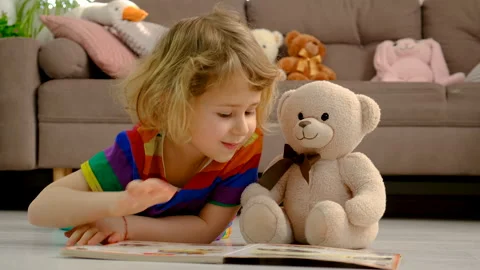 Children read a book to a teddy bear. Selective focus. Stock Footage 304216097