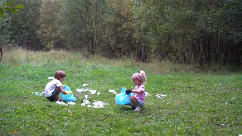 Children remove plastic garbage and put it in a biodegradable garbage bag Stock Footage 160690679