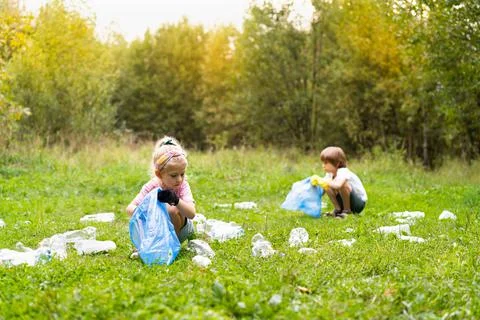 Children remove plastic garbage and put it in a biodegradable garbage bag in  Stock Photos