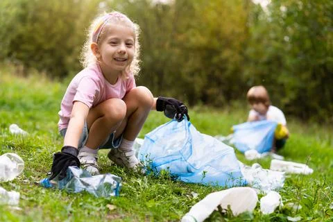 Children remove plastic garbage and put it in a biodegradable garbage bag in  Stock Photos