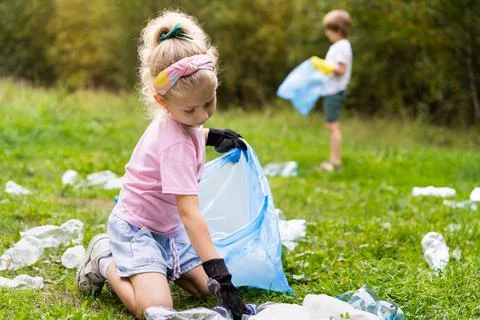 Children remove plastic garbage and put it in a biodegradable garbage bag in  Foto stock