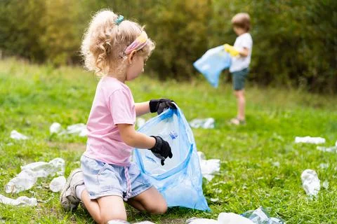 Children remove plastic garbage and put it in a biodegradable garbage bag in  Foto stock
