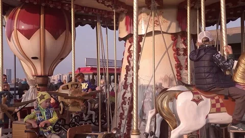 Children ride on a carousel Stock Footage 129521737