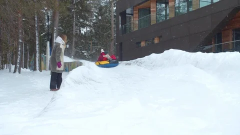Children ride on an ice slide. Slowmotion Video stock 129090466