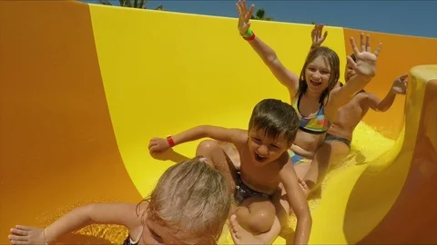 Children riding down orange slide in a water park Stock Footage 120092260
