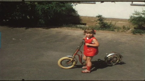 Children riding trike and bike in circles (vintage 8 mm amateur film) Stock Footage