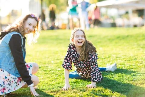 Children rolling down hill in grass Stock Photos