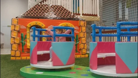 Children round the carousel turns in the play area. Dad rolls his daughter Stock Footage 70532282