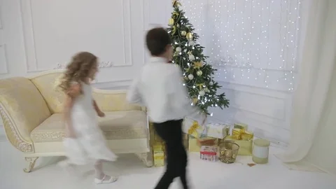 Children run to the Christmas tree to open gift Stock Footage 83300512