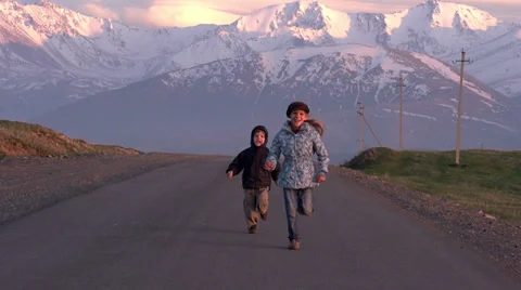 Children run into the setting Sun Stock Footage 24460687