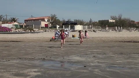 Children run into surf Stock-Footage 76310832