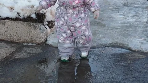 Children run through the puddles in the spring on a sunny day Stock Footage 170792188