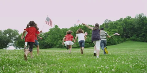 Children running with American flags on the 4th of July Stock Footage 49875897