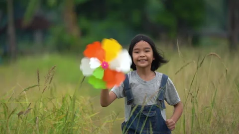 Children running and holding windmill on grassland in beautiful nature Video stock 179681663