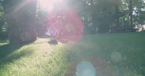 Children running around in garden and laughing,slow motion Stock Footage