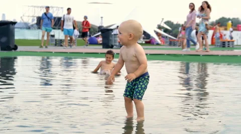 Children Running Around the Puddle Stock Footage 64764493
