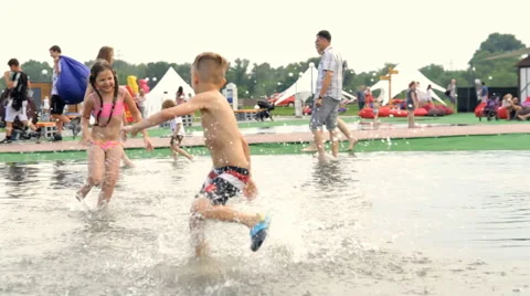 Children Running Around the Puddle Stock Footage 64767149