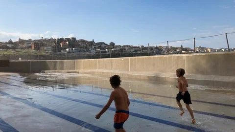 Children running in the empty pool Stock Footage 89740617