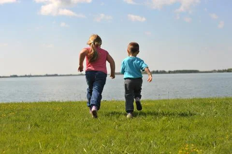Children running on the grass Stock Photos