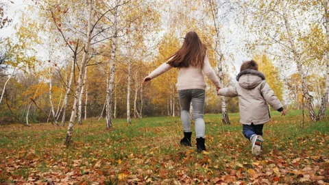 Children running holding hands through the autumn park Stock Footage 158611005