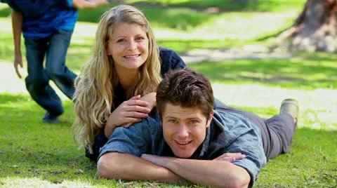 Children running to lie next to their parents Stock Footage