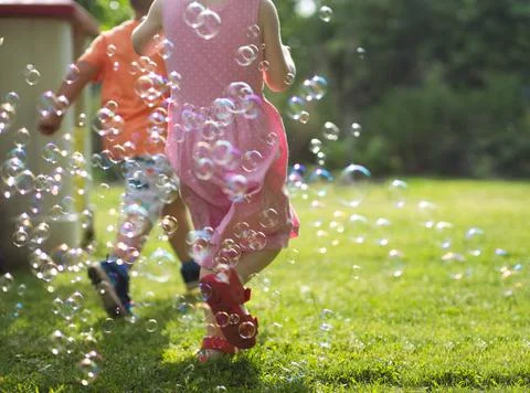 Children Running Through Soap Bubbles Stock Photos