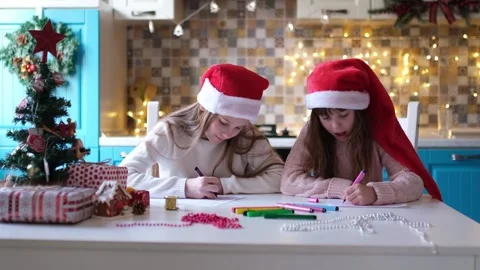 Children in Santa hats write a letter to Santa Claus in the Christmas decorated Stock Footage 166329035