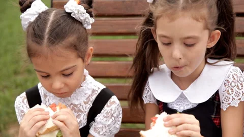 Children in school uniform after classes spend time in the park at the bottom of Stock-Footage 95764883