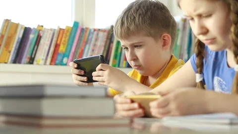Children at school using digital tablet technology. Boy and girl sharing togethe Stock Footage 87611652