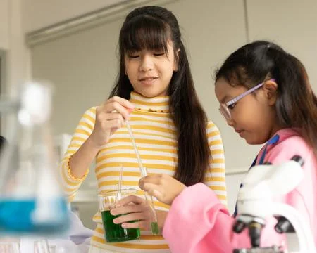 Children scientist doing science experiment test with chemistry in a labora.. Stock Photos