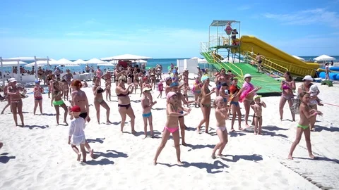 Children on the Sea Summer Beach dancing in Swimsuits do gymnastics exercises Stock Footage