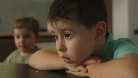 Children seated at table in kitchen using laptop, watching cartoons. Bad habit Stock Footage 238890214