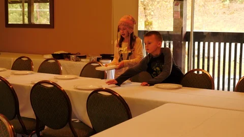 Children setting a large table for Thanksgiving Stock Footage 113874756
