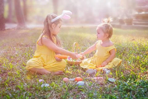 Children sit on the grass with easter eggs Stock Photos