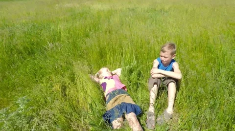 Children sit on the grass. 库存影片 51401604