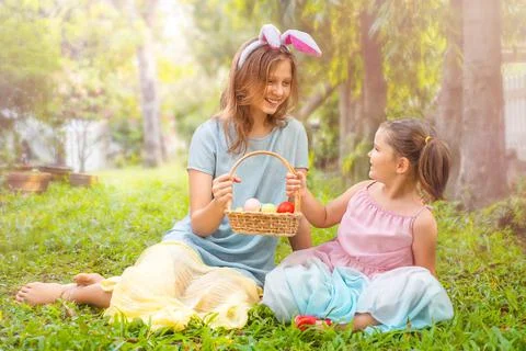 Children sit  hold a basket with easter eggs Stock Photos