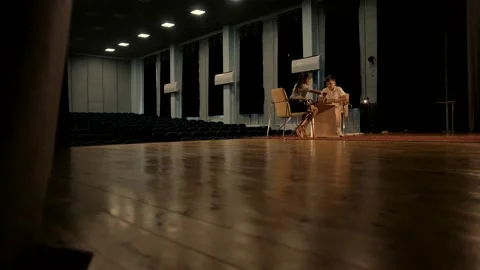 Children sit at a table in a large empty room and play a game of rapid chess. Stock Footage 156707948