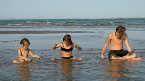 Children sitting at the beach and playing with sand. Kids enjoying summer v.. Stock Footage 284845482