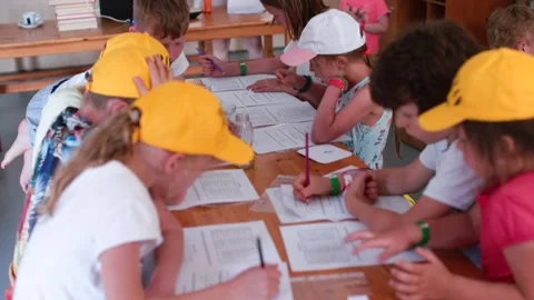 Children sitting table do joint tasks. Organization educational process vacation Stock Footage 133832117