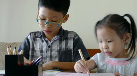 Children sitting at table drawing with colored pencils Stock Footage 67975156