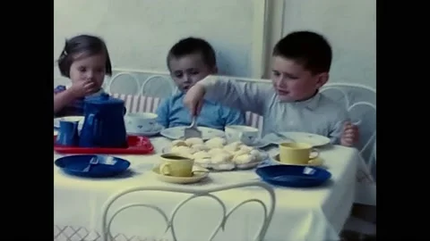 Children sitting at the table having breakfast in the 60s Stock Footage 205593033
