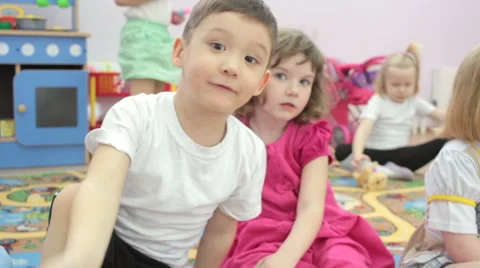 Children sitting at table waving  hands to camera. Stock Footage 62196745