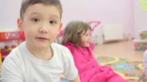 Children sitting  waving  hands to camera. in kindergarten 스톡 동영상 62196781