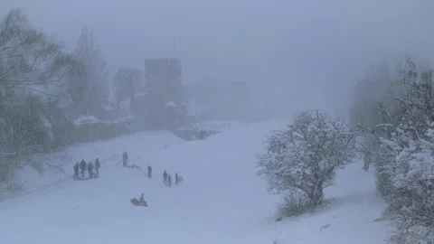 Children Sledding During Heavy Winter Snowfall at Nordergravar in Visby, Gotland Stock Footage 328587350