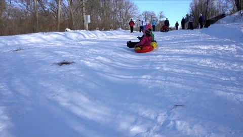 Children slide down a hill on an inflatable sled Video stock 85966701