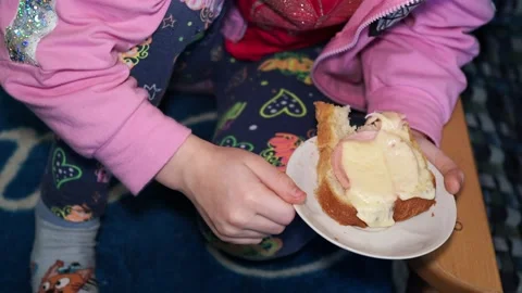Children. A small child eats a cheese sandwich. Close-up. Hand held. Video stock 169741564
