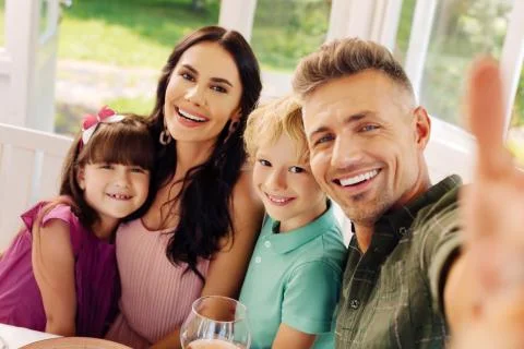 Children smiling while making selfie with mom and dad Foto stock