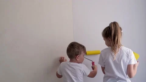 Children smooth the wallpaper on the wall with a roller. Stock Footage 150592007